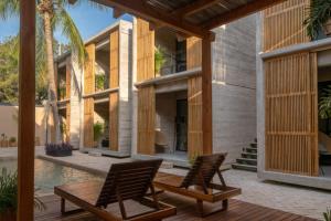two chairs sitting on a deck next to a house at Jiloo- Beautiful Oasis in Punta Zicatela 7 in Brisas de Zicatela