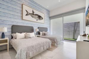 a bedroom with two beds and a striped wall at Medano Beach Pvt Jacuzzi Pool Marina Stylish in Cabo San Lucas +24 photos