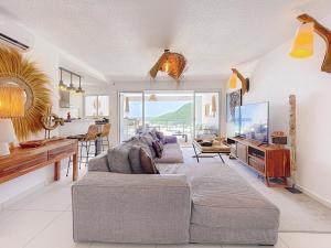 a living room with a couch and a tv at Koala1 Elegant 1BR Duplex, Anse Marcel, Sea View in Anse Marcel 