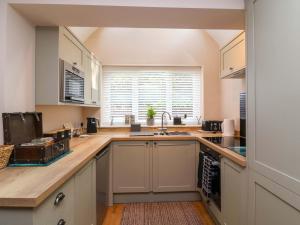 a kitchen with white cabinets and a sink at Poddington Cottage in Salisbury