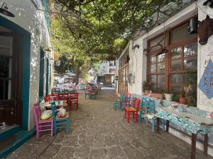 a street with colorful chairs and tables on a building at Gorgeous restored house at Platanos square in Plomari