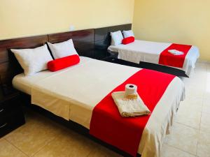 two beds in a room with red and white at Royal Plaza Hotel Suite in Nueva Cajamarca