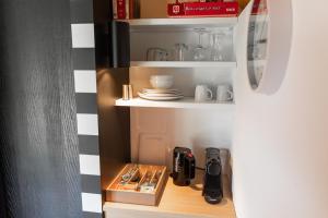 a small kitchen with a cupboard with utensils at B&B Hof van Heden in Enschede +11 photos
