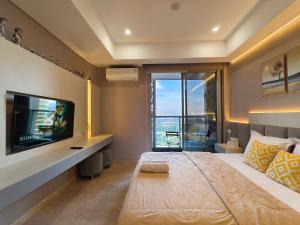 a bedroom with a large bed and a television at Studio Sea View Apartment at Gold Coast PIK by MYsweethome in Jakarta