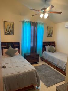 a bedroom with two beds and a ceiling fan at Sunset Villas MWV in Montego Bay
