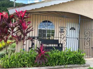 a gate with a bench in a garden at Sunset Villas MWV in Montego Bay
