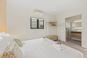 a white bedroom with a white bed and a bathroom at Villa Mambo Beach with Private Pool in Willemstad +26 photos