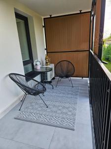 a balcony with two chairs and a table at Biała Perła - Apartament Augustów in Augustów