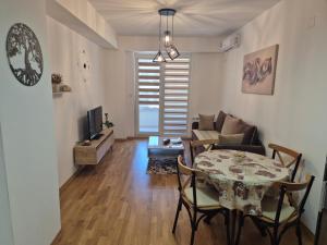 a living room with a table and a couch at Golden 23 Skopje in Skopje