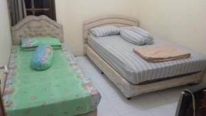Un pat sau paturi într-o cameră la Rumah Liburan Turangga