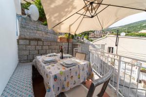 a table on a balcony with an umbrella at La casa di Grace in Seccheto