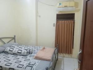 Un pat sau paturi într-o cameră la Rumah Liburan Turangga
