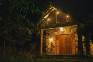 een stenen huis met een houten deur 's nachts bij Lakeshore Resort in Anuradhapura