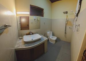 een badkamer met een wastafel en een toilet bij Lakeshore Resort in Anuradhapura