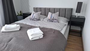 a bedroom with a bed with towels on it at P R A T U M Plus in Mikołajki