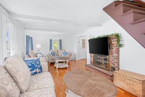 a living room with a fireplace and a tv at 61 Carman Avenue Sandwich - Old Harbor House in Sandwich