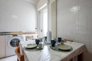 a kitchen with a table and a washing machine at Dimora Waterfront in Bari
