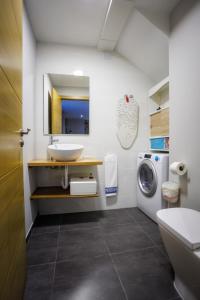 a bathroom with a sink and a washing machine at Casa Yañez • XuresVillas in Bubaces