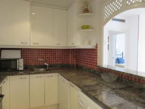 a kitchen with white cabinets and a counter top at Apartamentos Las Brisas 3-2 in Torroella de Montgrí +6 photos