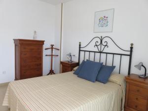 a bedroom with a large bed with blue pillows at Apartamentos Las Brisas 3-2 in Torroella de Montgrí