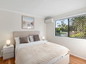 ein weißes Schlafzimmer mit einem Bett und einem Fenster in der Unterkunft Sunnybank Hills Retreat 6 Beds Near Market Square in Brisbane