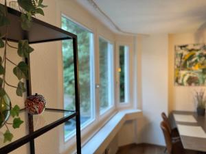 a dining room with a table and a window at Der Platzhirsch - Design-Apartment in grüner Oase in Freiburg im Breisgau +23 photos