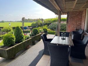 a table and chairs on a patio with a garden at Vakantiehuis in Twente in Vasse +29 photos