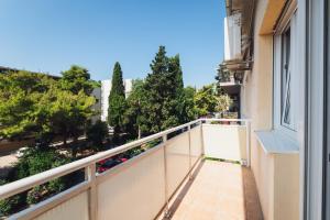 a balcony with a white railing and trees at Spinut Urban Retreat in Split