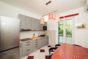 a kitchen with white cabinets and a table with chairs at Spinut Urban Retreat in Split