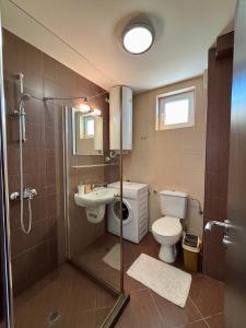 a bathroom with a shower and a toilet and a sink at Sunset Deluxe in Kosharitsa +15 photos
