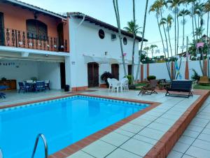 a swimming pool in front of a house at Cantinho no litoral a 100mts da praia in São Sebastião