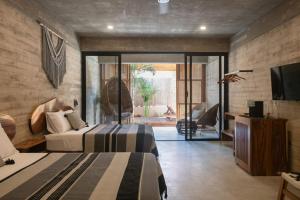 a bedroom with two beds and a television in a room at Jiloo- Beautiful Oasis in Punta Zicatela 7 in Brisas de Zicatela +5 photos