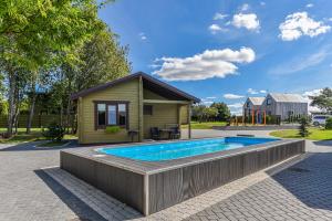 a swimming pool in front of a tiny house at Resort Baure in Palanga