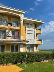 a yellow building with bushes in front of it at Sunset Deluxe in Kosharitsa