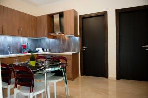 a kitchen with a black door and a table and chairs at Serenita Apartments in Ermones