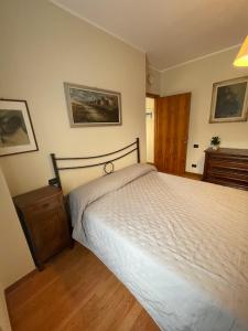 a bedroom with a white bed and a wooden floor at Il cortile da Tania in Zanica +8 photos