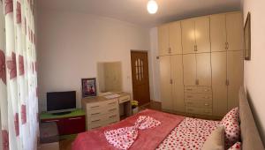 a bedroom with a bed and a tv and cabinets at Zoto Guest House in Përmet