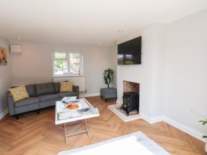 a living room with a couch and a fireplace at Manor Cottage in Harpham