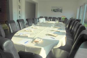 een grote vergaderzaal met een lange tafel met stoelen bij Hotel Temse in Temse