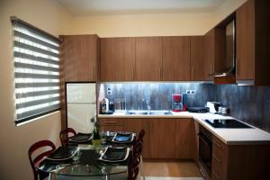 una cocina con mesa y sillas y una cocina con armarios de madera. en Serenita Apartments, en Ermones