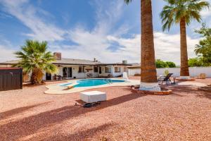 a house with a swimming pool and two palm trees at Walk to Golf Club Sun City Home with Private Pool! in Sun City