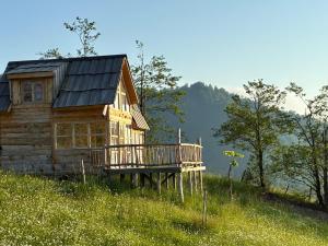 a log cabin on a hill with a deck at JUSA ჯუსა in Kantauri +18 photos