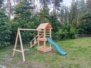 a wooden playground with a slide and a swing at Dwór pod Sosnami Kaszuby, sauna in Ostrzyce +94 photos