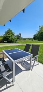 a ping pong table and two chairs on a patio at Bergidylle- Saniert und Hochwertig mit Massivholzmöbeln, Sonnenterrasse in der Natur, fußgängig ins Zentrum in Kurort Altenberg
