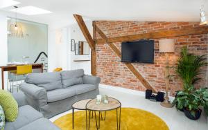 a living room with a couch and a brick wall at Grodzka6 in Bydgoszcz