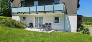 a house with a table and chairs in front of it at Bergidylle- Saniert und Hochwertig mit Massivholzmöbeln, Sonnenterrasse in der Natur, fußgängig ins Zentrum in Kurort Altenberg