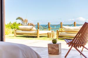 two benches sitting on a patio with a view of the ocean at Villa Mandi in Jericoacoara +15 photos