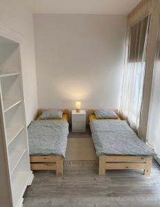 グディニャにあるTanie Noclegi Gdyniaの窓のある部屋にツインベッドが2台