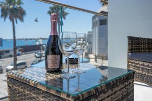 a bottle of wine and two wine glasses on a table at Nery Home Luxury Sea View Giardini Naxos in Giardini Naxos