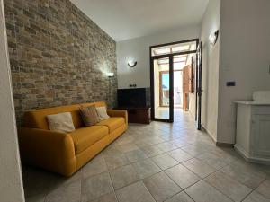 a living room with a couch and a brick wall at Casa di Flavio in Castelsardo